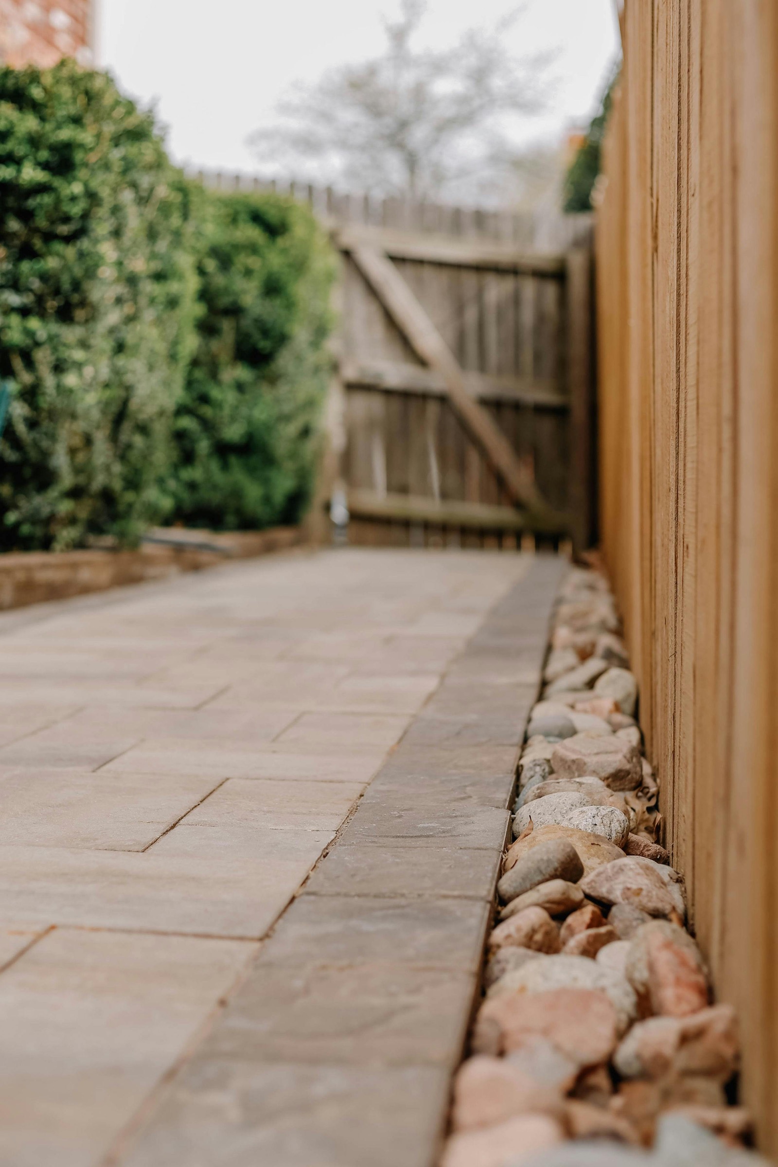 Paver path detail with stone edging and a wood fence